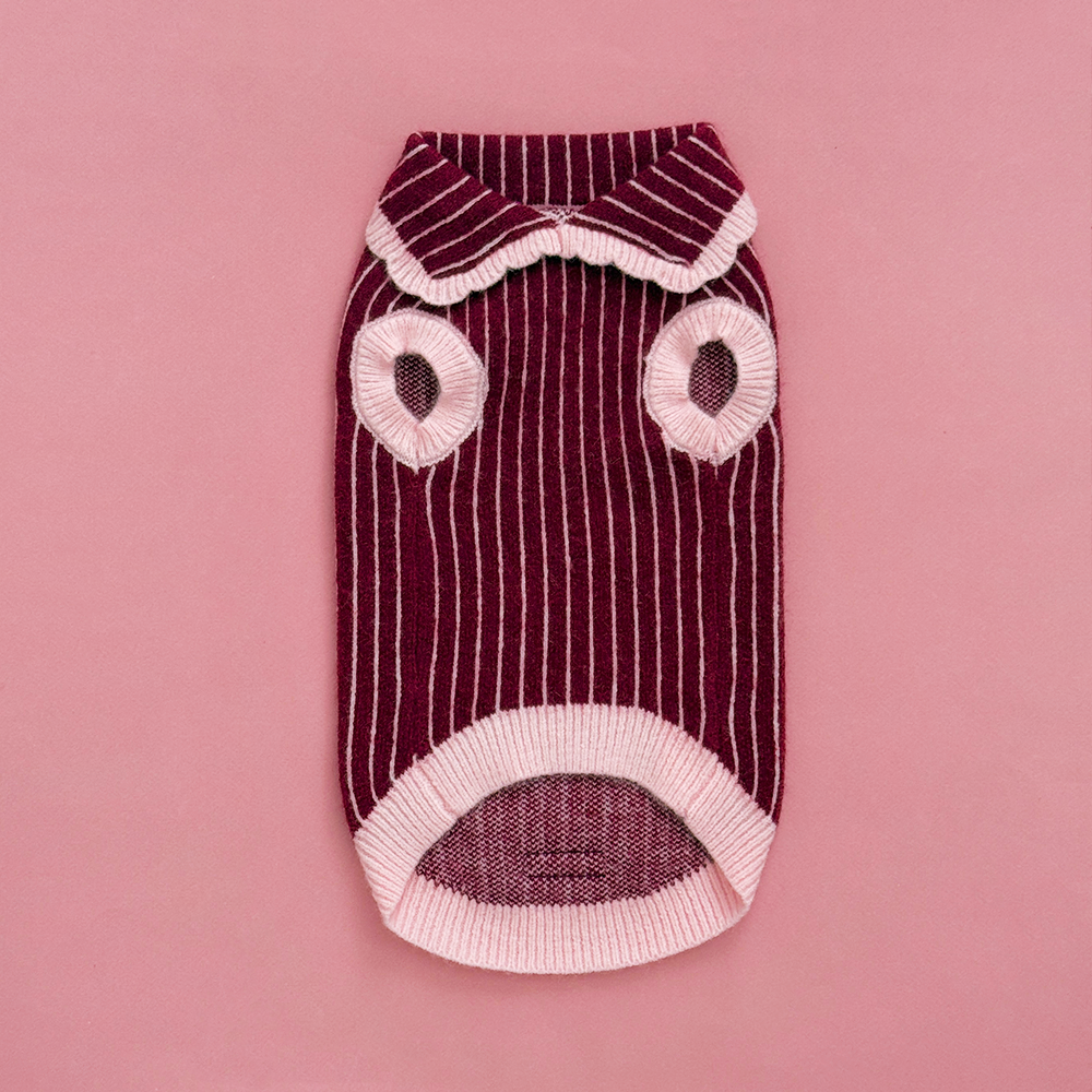 Knitted dog jumper in burgundy with thin baby pink vertical stripes, featuring a pink collar with scalloped edging.