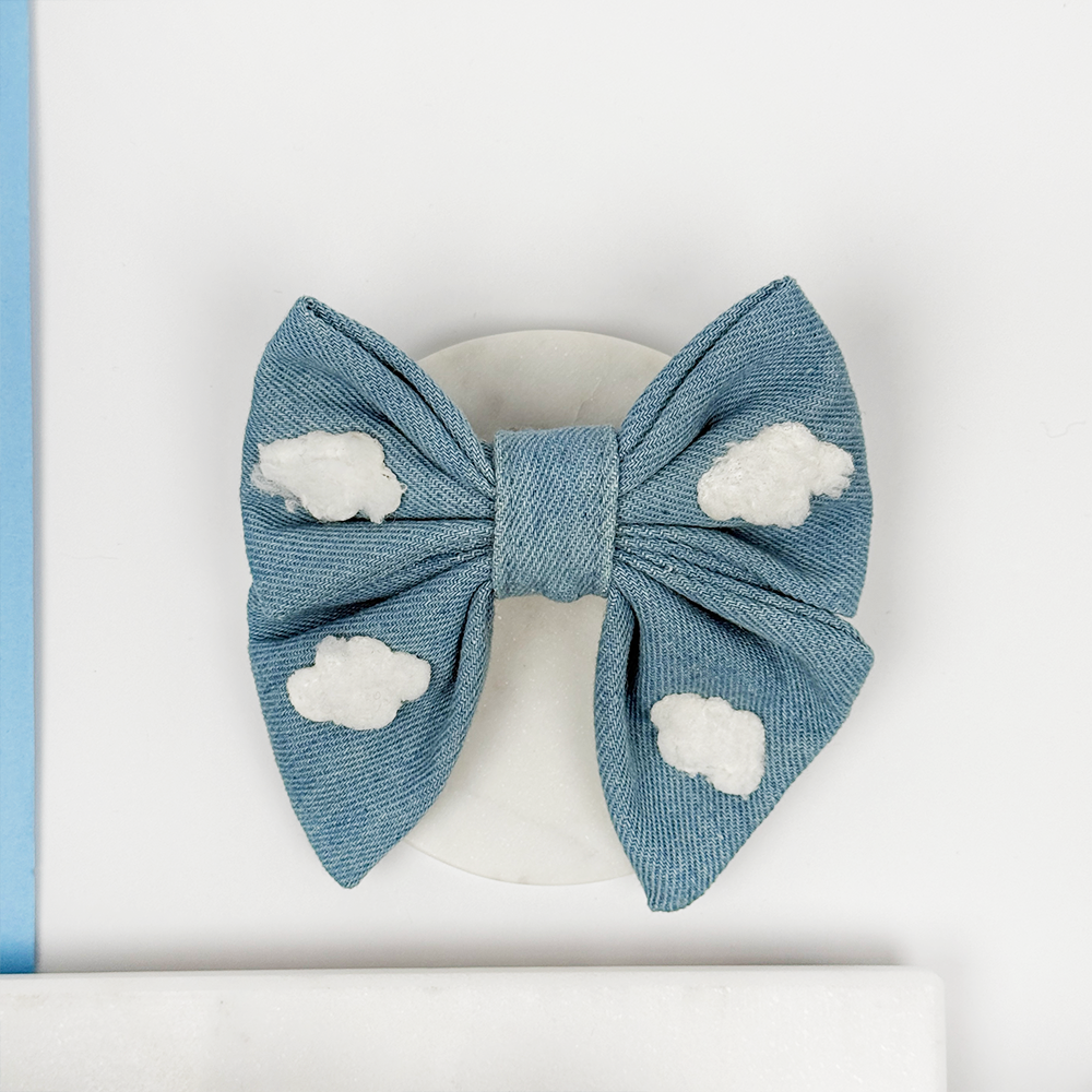 Blue denim bow with white cloud patterns on a white background
