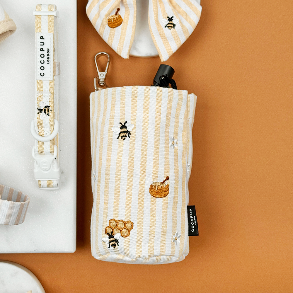Pale yellow and white striped Drawstring Treat Pouch with bee and honeycomb embroidered decals. 