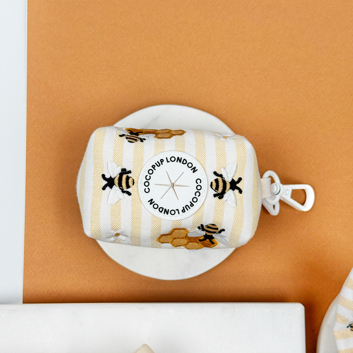 Pale yellow and white striped Dog Poop Bag Holder with bee and honeycomb embroidered decals. 
