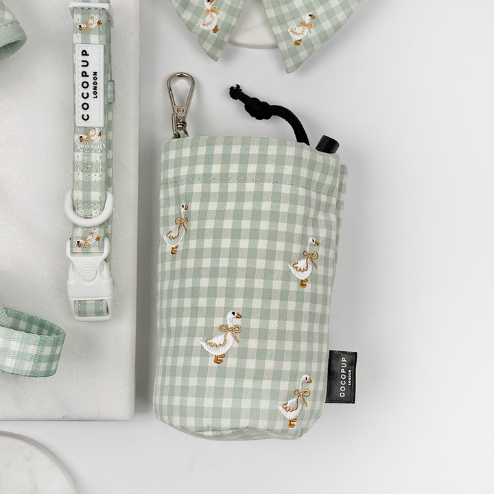 Green and white check print drawstring treat pouch for dogs with embroidered geese design.